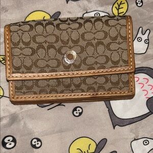 This is a vintage Coach signature canvas card holder or small accordion wallet.